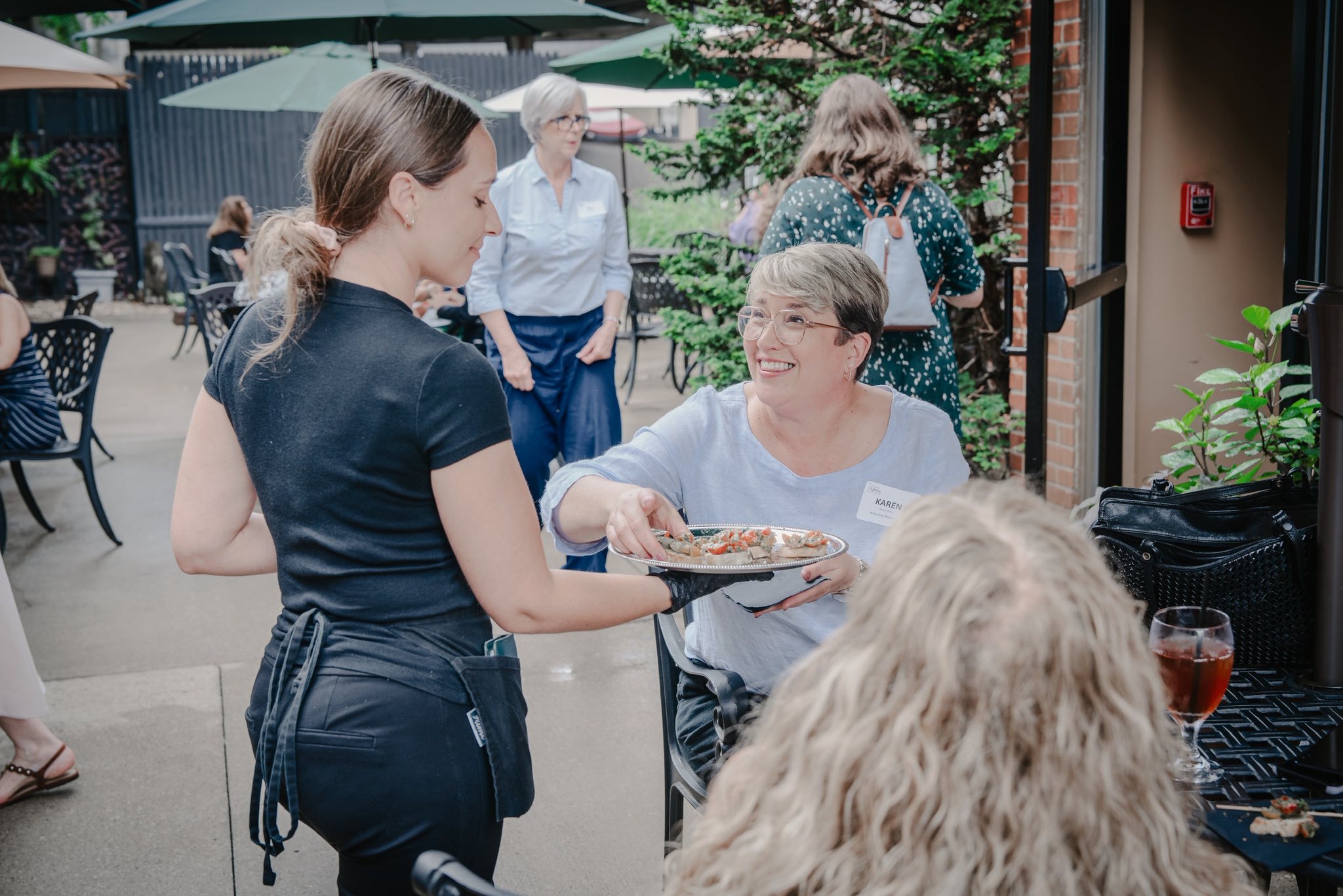 a J. Corks server sharing appetizers with an event attendee